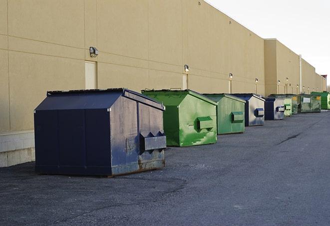 a row of blue construction dumpsters on a job site in Loon Lake